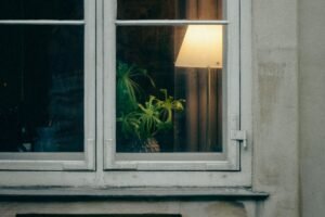 Tropfflasche trägt Öl auf Fensterscharnier auf