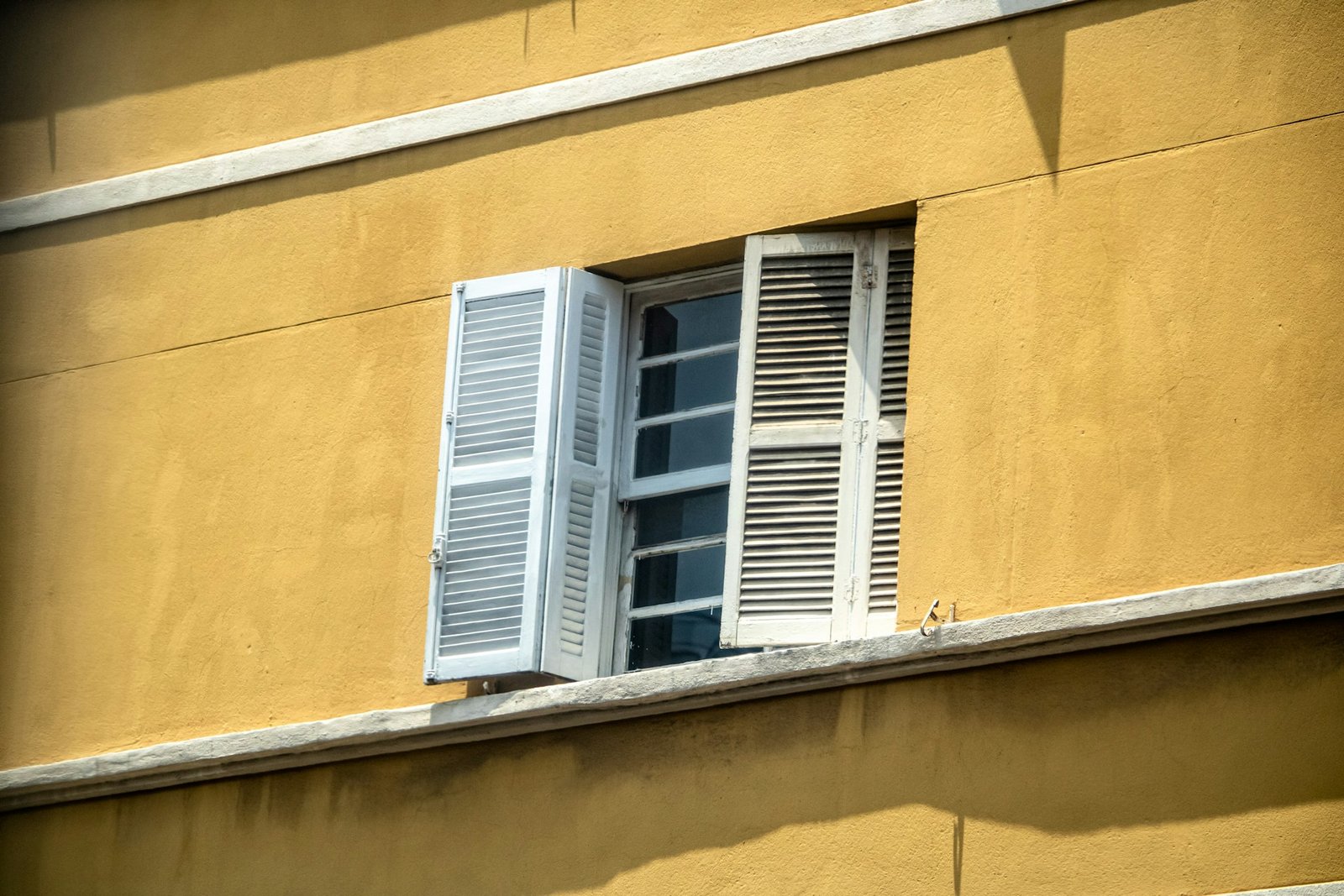 Nahaufnahme eines Fenster­scharniers am geöffneten Fenster