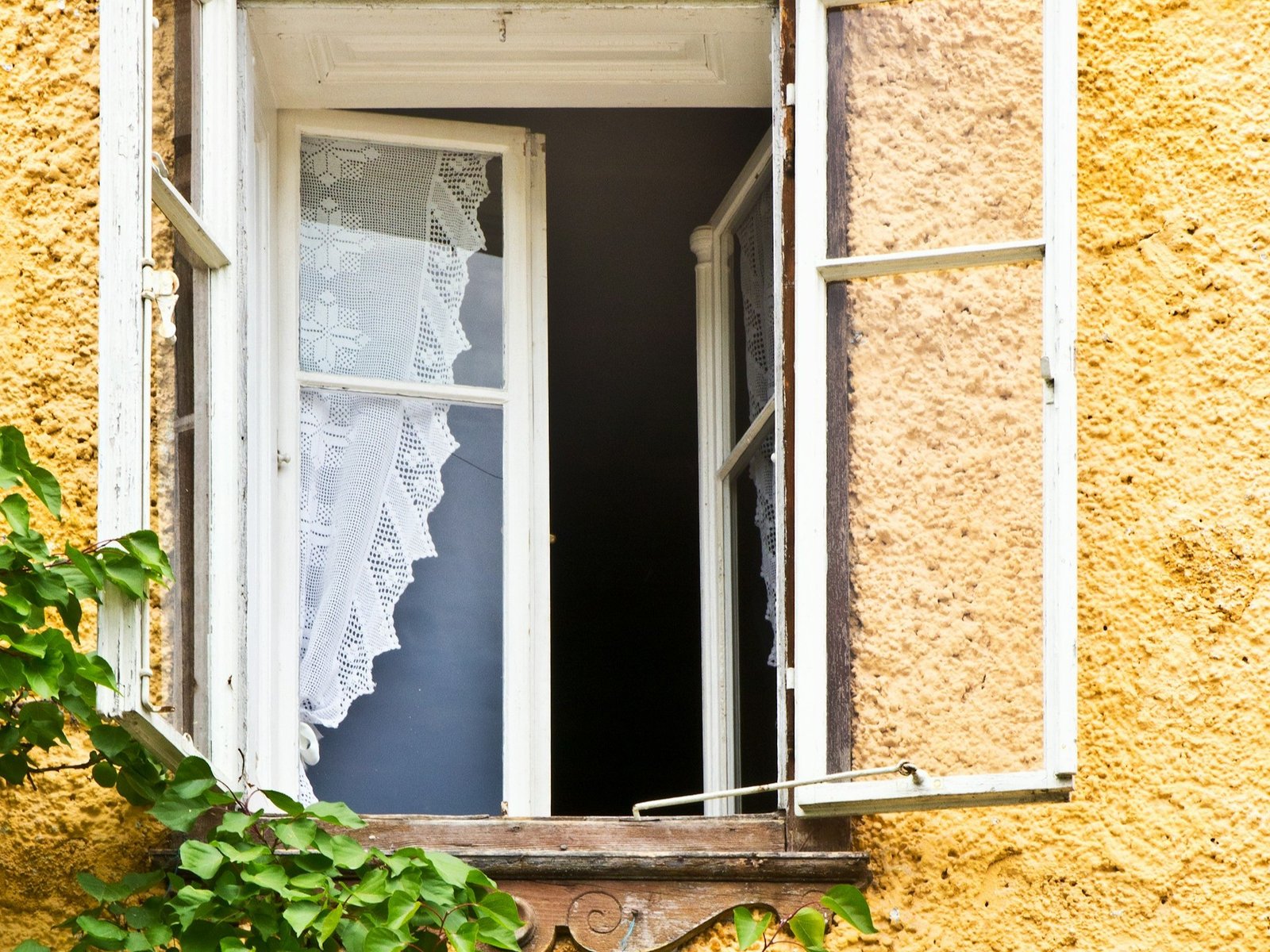 Geschlossenes Fenster mit bewegtem Vorhang durch Wind