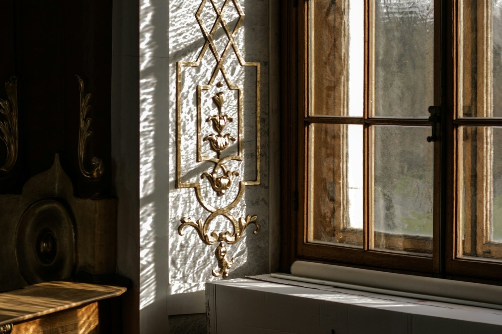 Hand reinigt Metallbeschlag am geöffneten Fenster mit einem Tuch