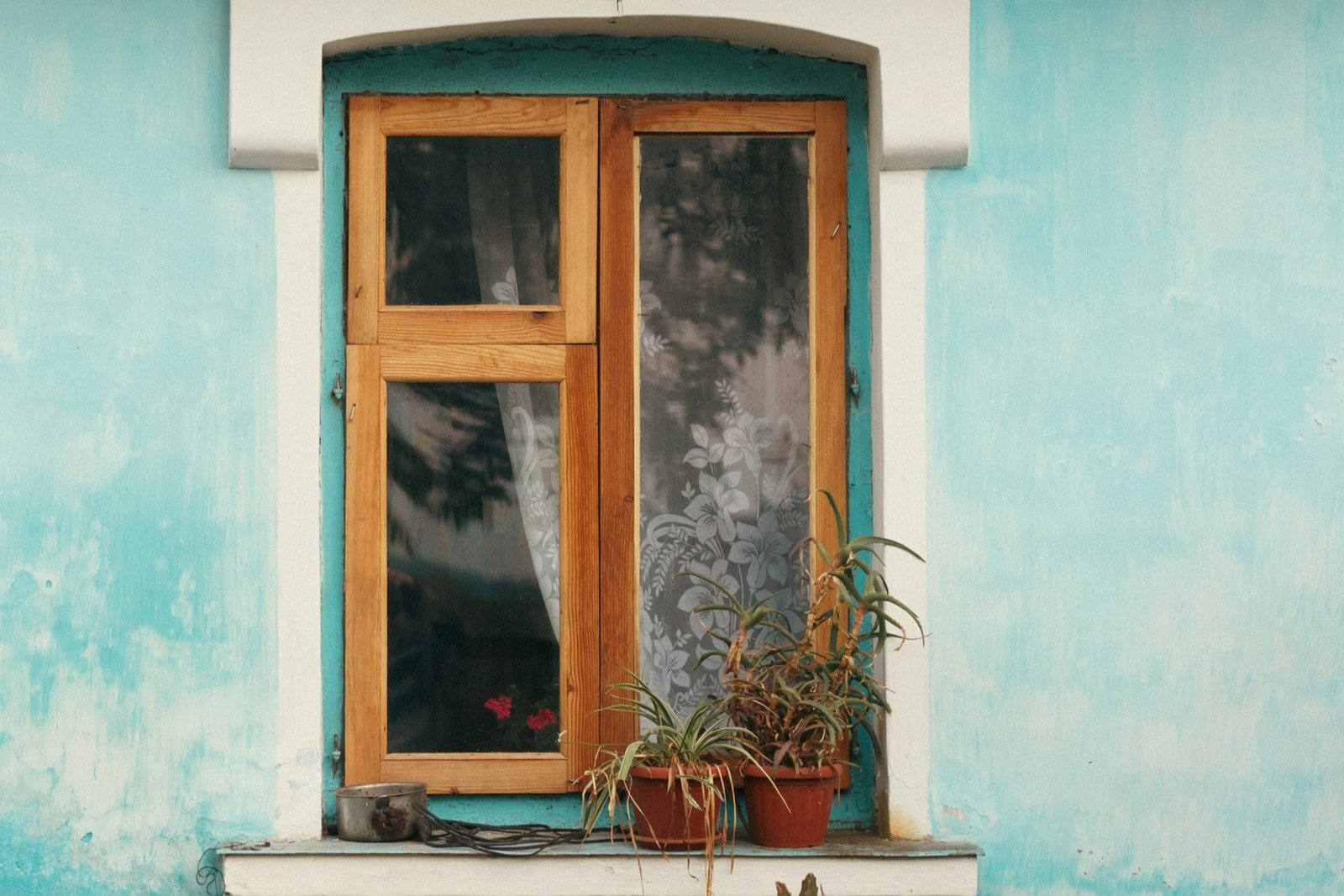 Altes Kastenfenster mit sichtbarem Metallscharnier und Holzrahmen