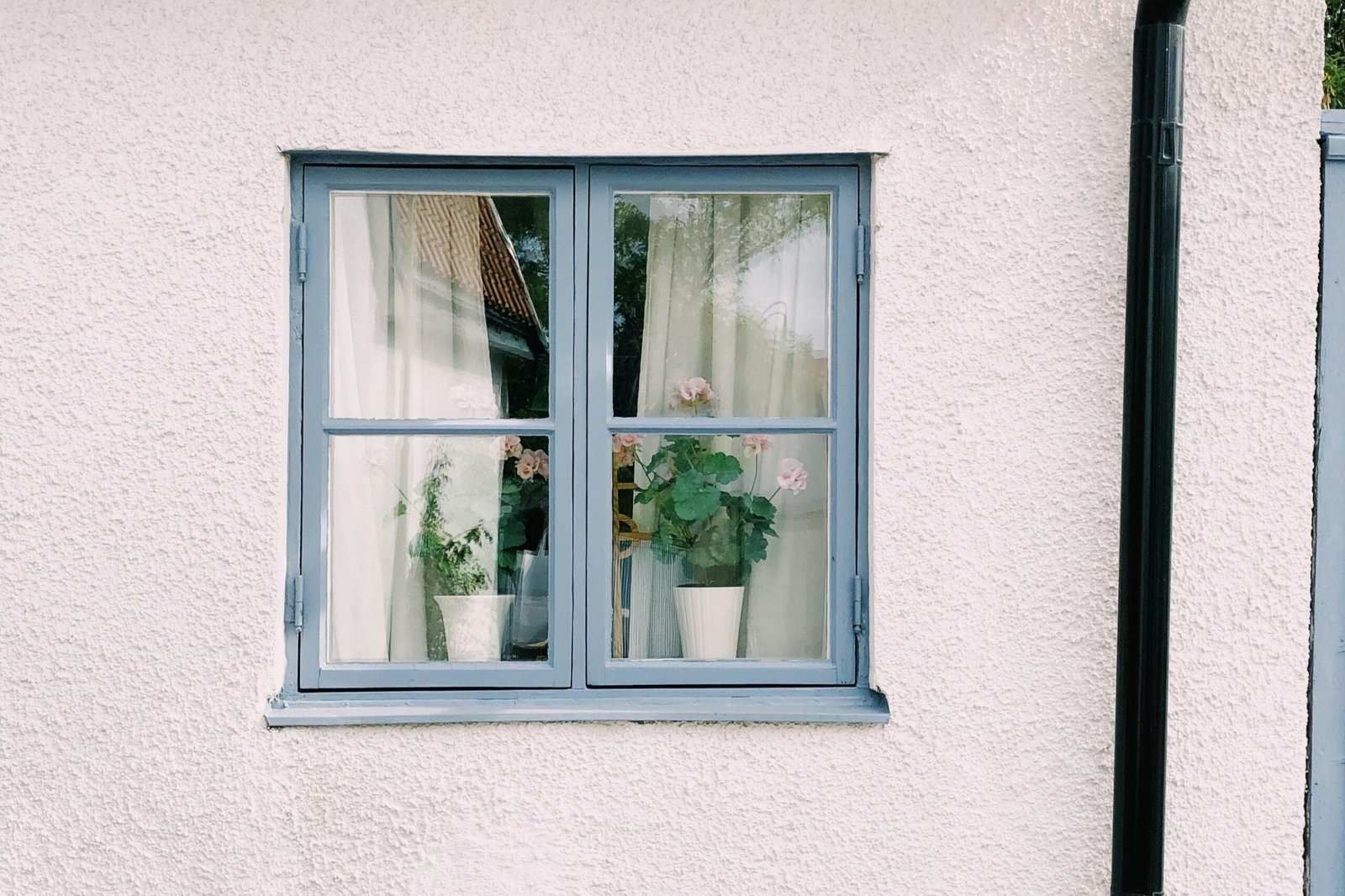 Fachperson prüft ein Fensterscharnier am geöffneten Fenster