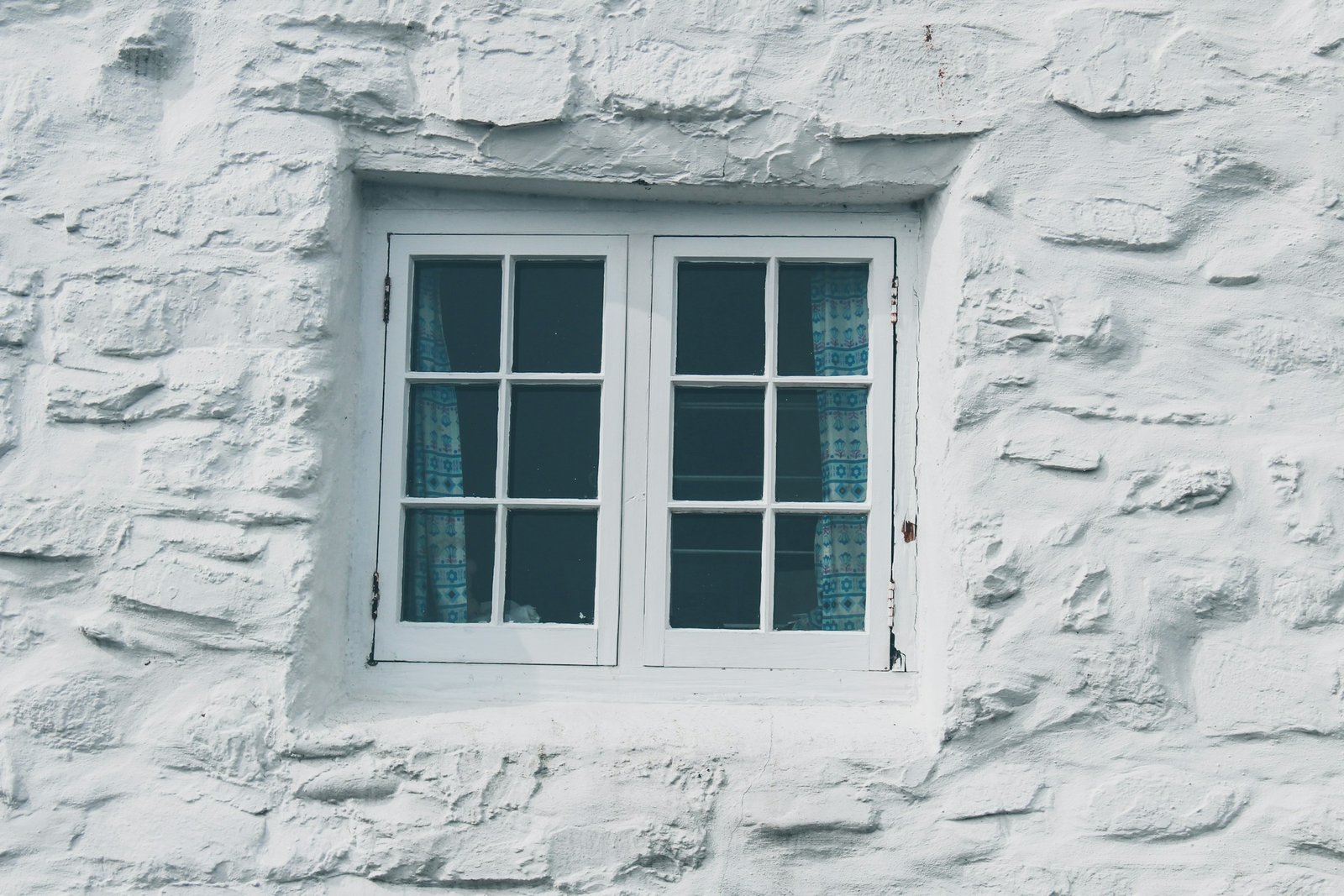Detailaufnahme eines Metall-Scharniers an einem Fensterrahmen